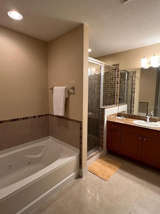 bathroom with a textured ceiling, separate shower and tub, vanity, and tile patterned floors