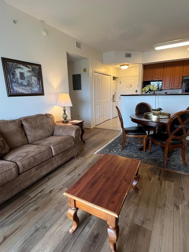 living room with light hardwood / wood-style flooring and washer / dryer