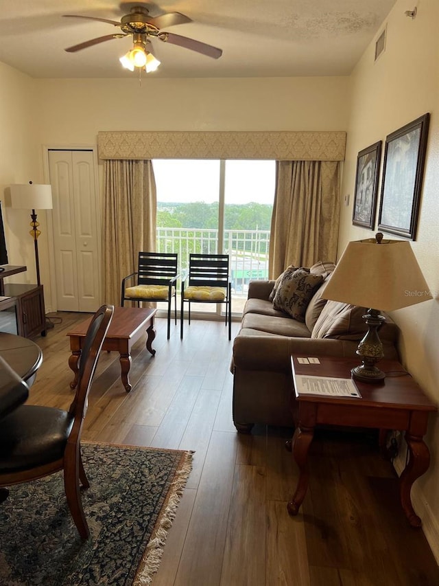 living room featuring ceiling fan and hardwood / wood-style flooring