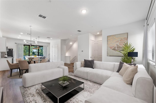 living room featuring a notable chandelier and light hardwood / wood-style flooring