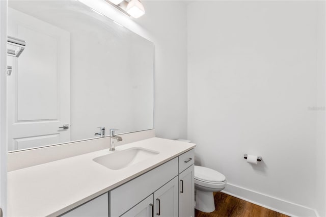 bathroom with vanity, hardwood / wood-style floors, and toilet