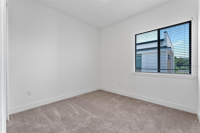 spare room featuring light colored carpet