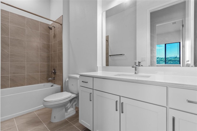 full bathroom with tile patterned flooring, tiled shower / bath, vanity, and toilet