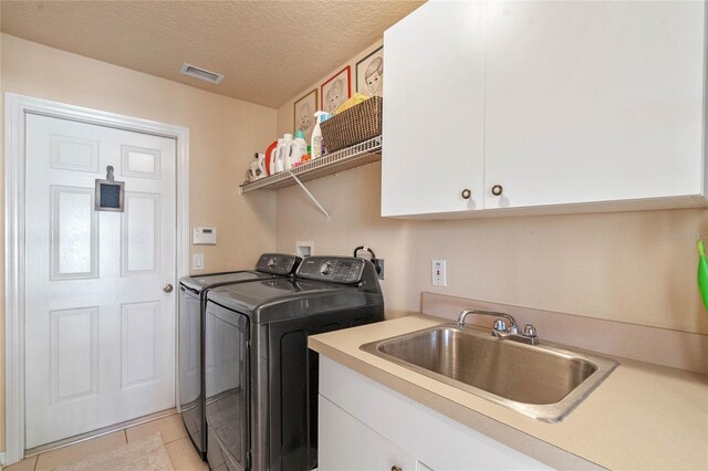 404 Hightower Dr, Debary, FL 32713 - laundry area with separate washer and dryer, cabinet space, light tile patterned floors, and a textured ceiling