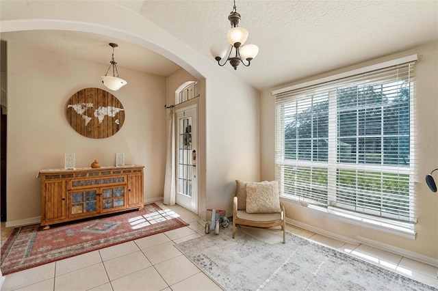404 Hightower Dr, Debary, FL 32713 - sitting room featuring arched walkways, tile patterned floors, baseboards, and a textured ceiling