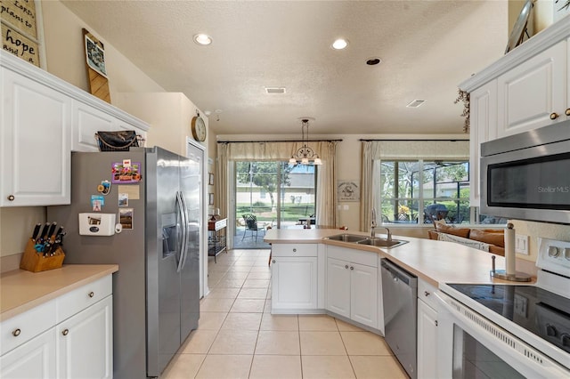 404 Hightower Dr, Debary, FL 32713 - kitchen with appliances with stainless steel finishes, a sink, light tile patterned floors, white cabinetry, and a textured ceiling