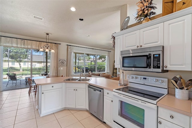 404 Hightower Dr, Debary, FL 32713 - kitchen with stainless steel appliances, a sink, a peninsula, a textured ceiling, and light countertops