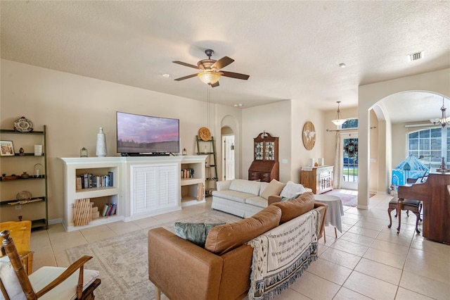 404 Hightower Dr, Debary, FL 32713 - living room featuring arched walkways, light tile patterned floors, a ceiling fan, a textured ceiling, and baseboards