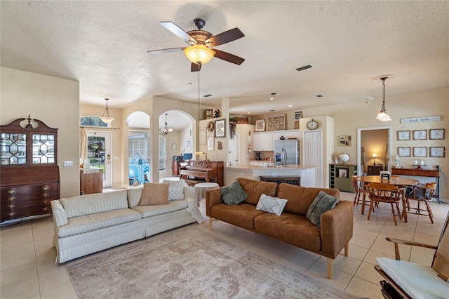 404 Hightower Dr, Debary, FL 32713 - living area featuring light tile patterned flooring, arched walkways, a textured ceiling, and a ceiling fan