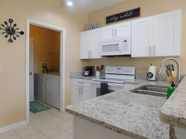 kitchen featuring white cabinetry, separate washer and dryer, sink, light stone countertops, and white appliances