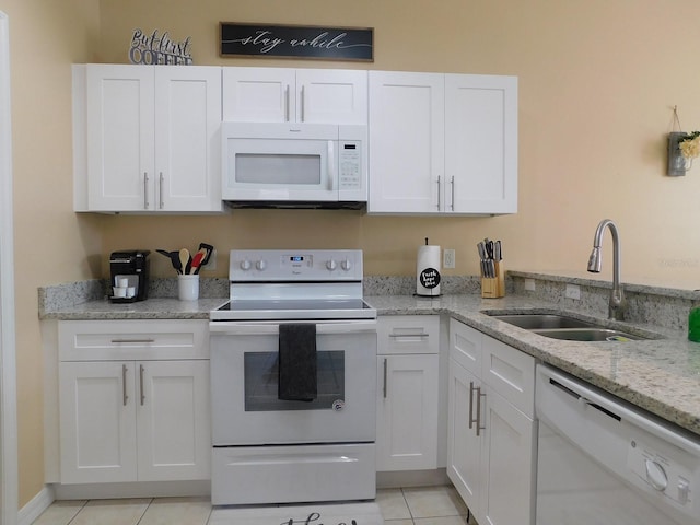 kitchen featuring light tile patterned flooring, sink, white cabinetry, light stone counters, and white appliances