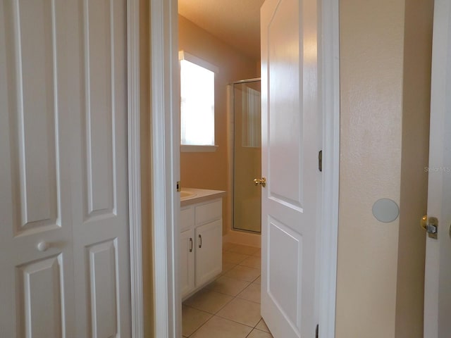 bathroom with tile patterned flooring, vanity, and walk in shower