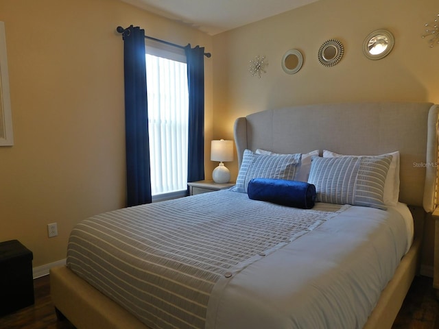 bedroom with dark hardwood / wood-style floors