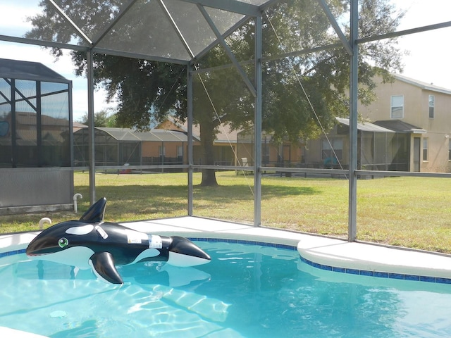 view of swimming pool featuring glass enclosure and a lawn