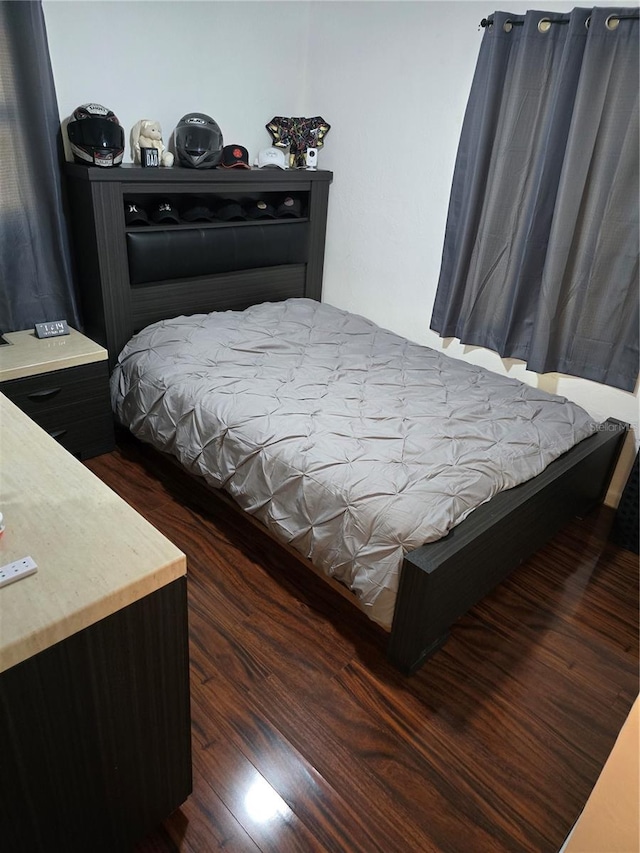 bedroom with dark hardwood / wood-style flooring