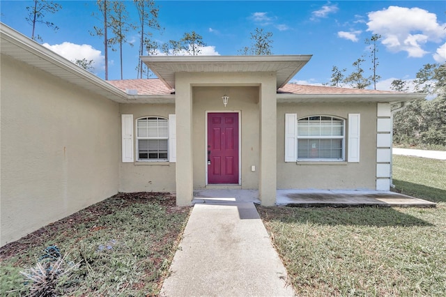 doorway to property with a lawn