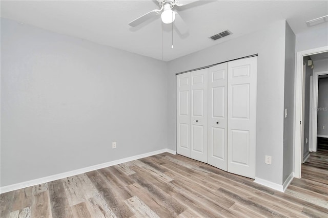 unfurnished bedroom with wood-type flooring, a closet, and ceiling fan