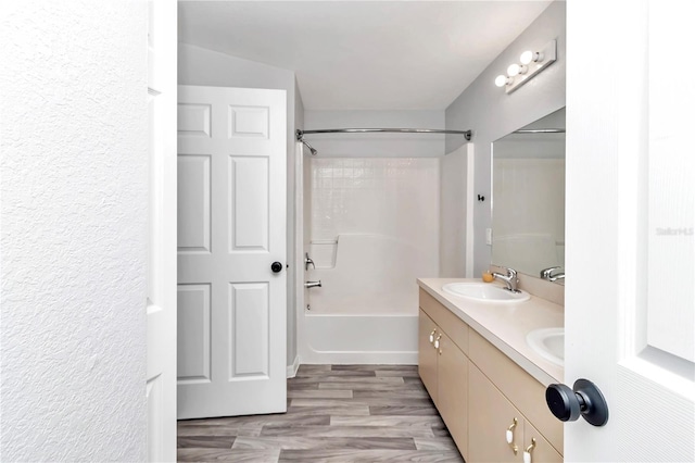 bathroom featuring shower / washtub combination, wood-type flooring, and double sink vanity