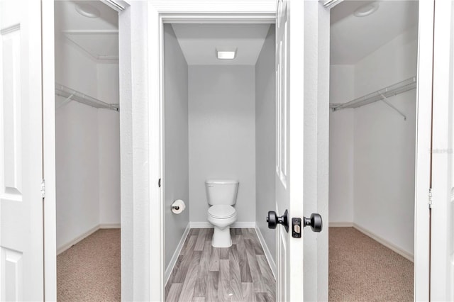 bathroom with toilet and hardwood / wood-style flooring