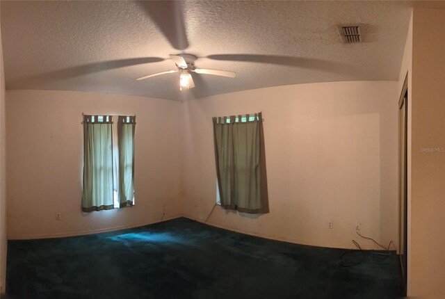 unfurnished room with carpet flooring, a textured ceiling, ceiling fan, and lofted ceiling