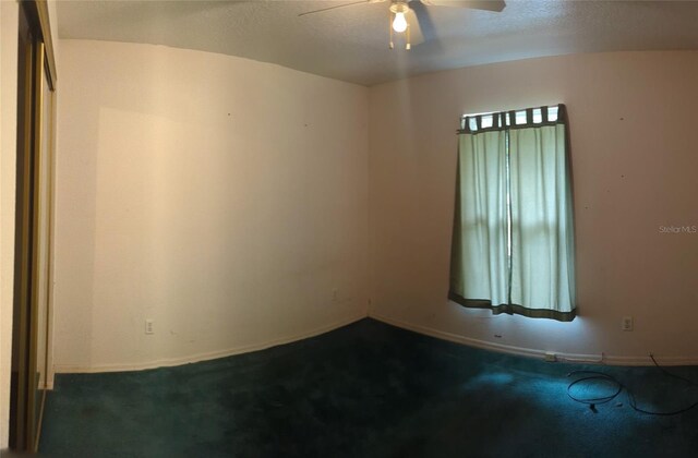 carpeted empty room featuring a textured ceiling and ceiling fan