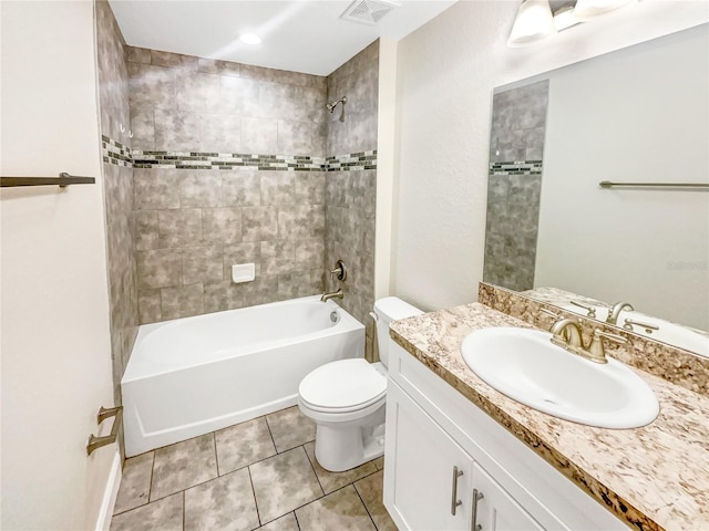 full bathroom featuring tiled shower / bath combo, vanity, tile patterned floors, and toilet