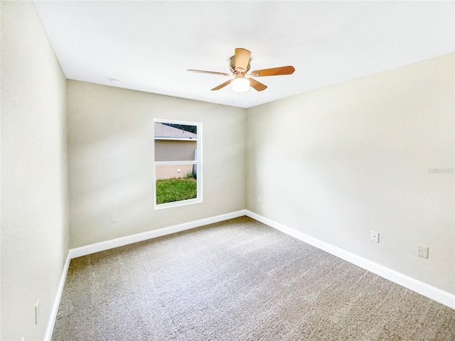 carpeted spare room featuring ceiling fan