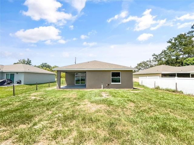 back of house featuring a patio and a yard