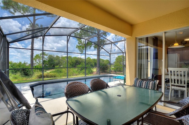 view of swimming pool featuring a patio and glass enclosure