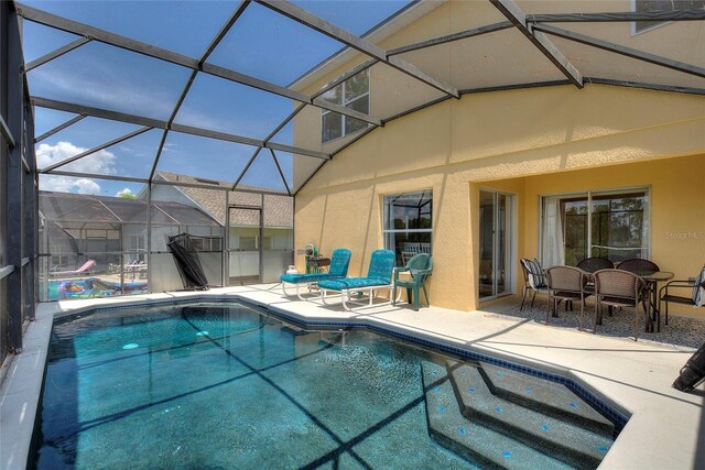 view of pool with a patio and glass enclosure