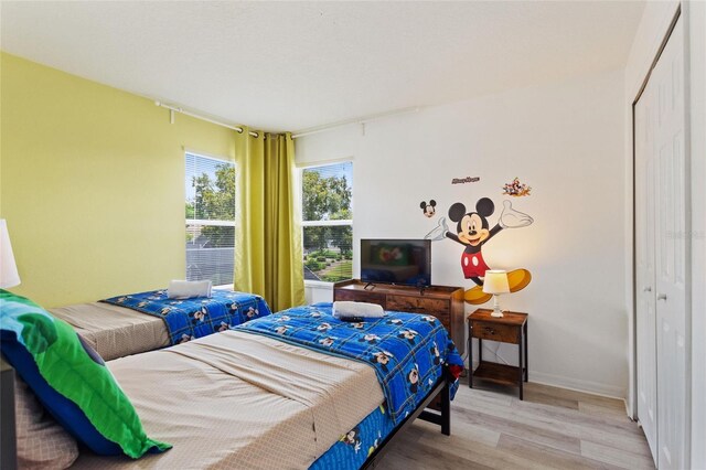 bedroom with wood-type flooring and a closet