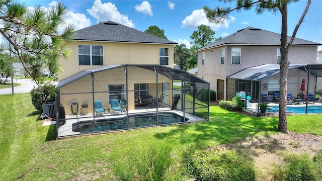 rear view of property with a yard, a patio area, and a lanai