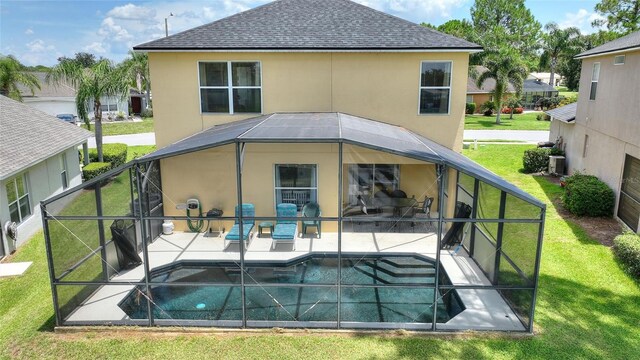 rear view of property with a patio area, a lawn, a fenced in pool, and a lanai