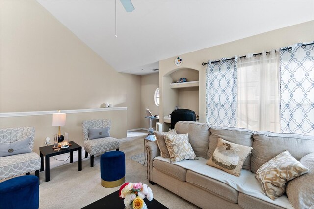 carpeted living room with built in features and vaulted ceiling