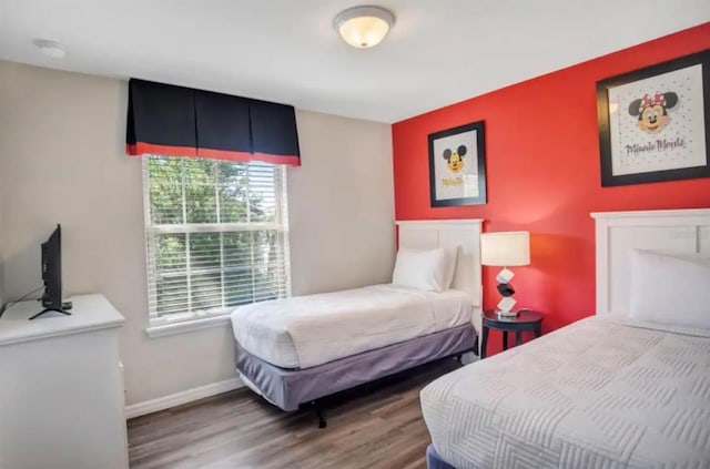 bedroom with wood finished floors and baseboards