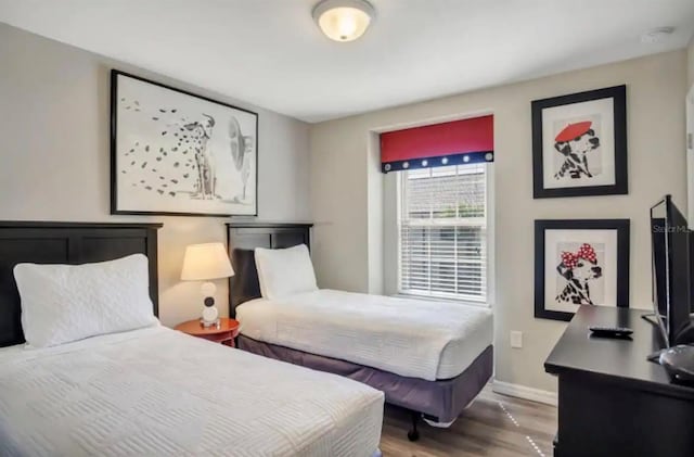 bedroom with baseboards and wood finished floors