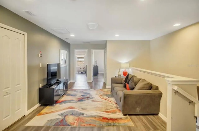 living area with recessed lighting, baseboards, visible vents, and light wood finished floors