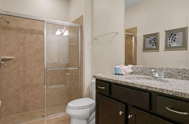 bathroom with tile patterned flooring, vanity, toilet, and a shower stall