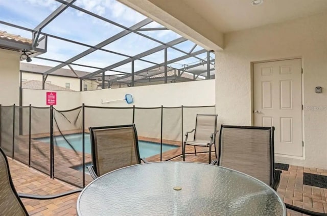 view of patio with a fenced in pool, outdoor dining space, and a lanai