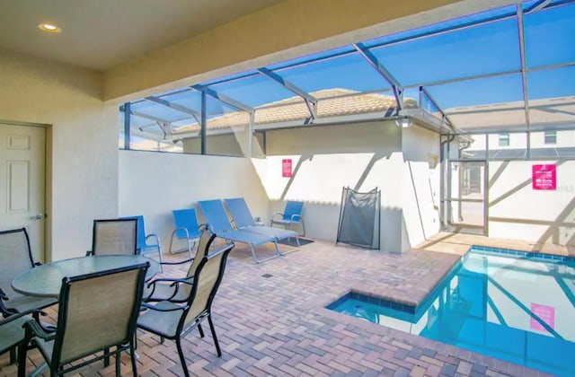 pool with glass enclosure and a patio