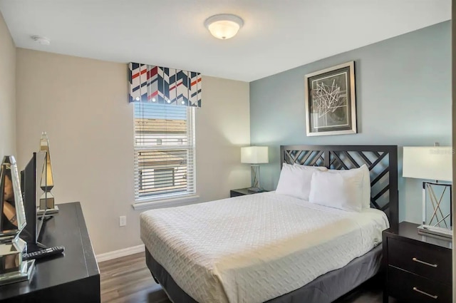 bedroom featuring dark wood-style floors and baseboards