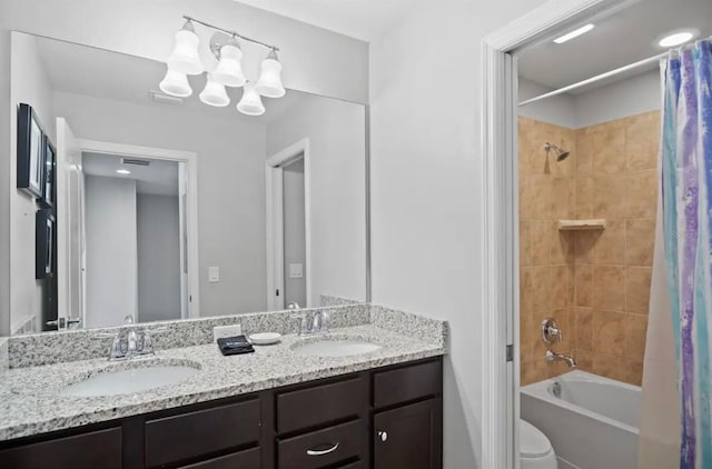 bathroom with a sink, toilet, shower / bathtub combination with curtain, and double vanity