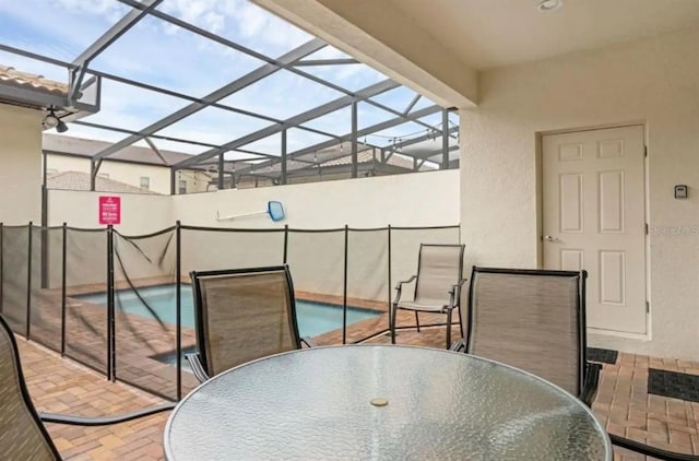 view of patio featuring outdoor dining area and a lanai