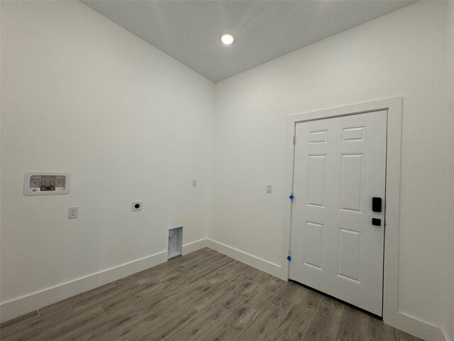 laundry area featuring washer hookup, electric dryer hookup, wood finished floors, laundry area, and baseboards