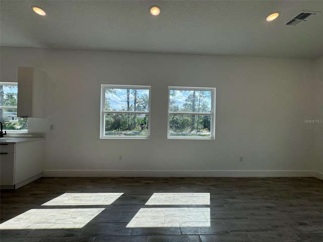 spare room with dark wood-type flooring, recessed lighting, visible vents, and baseboards