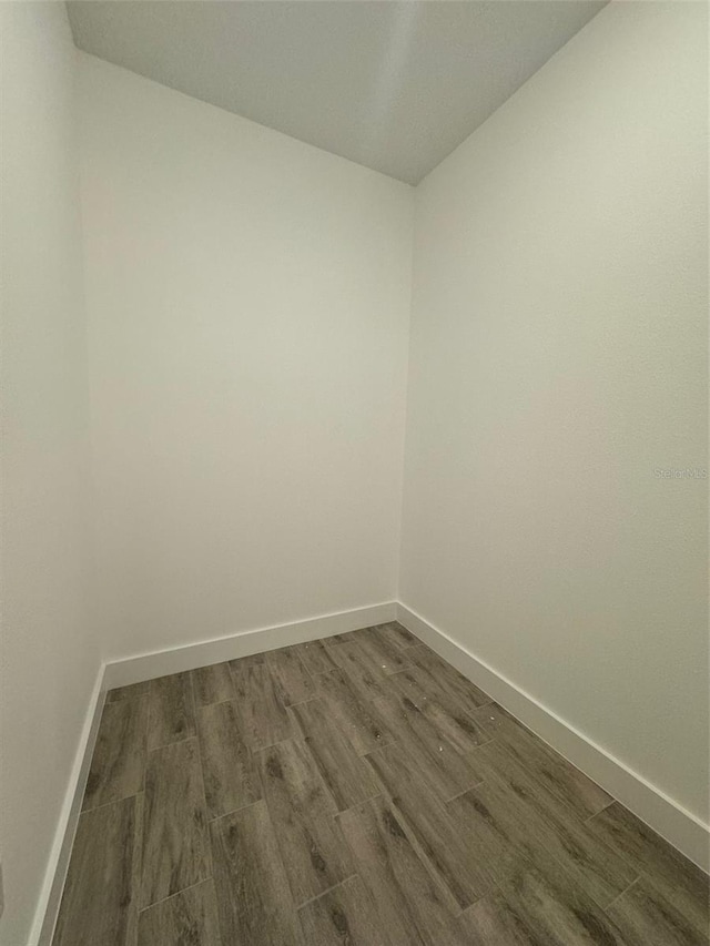 empty room with dark wood-style floors and baseboards