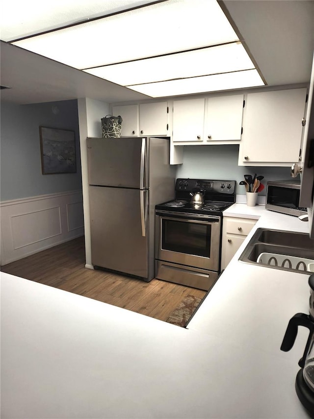 kitchen featuring dark wood-type flooring, stainless steel appliances, sink, and white cabinets