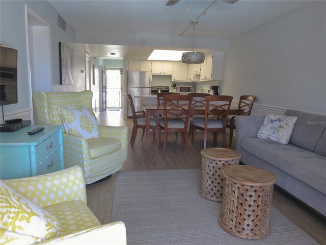 living room with hardwood / wood-style floors and ceiling fan