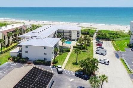 drone / aerial view featuring a water view and a beach view