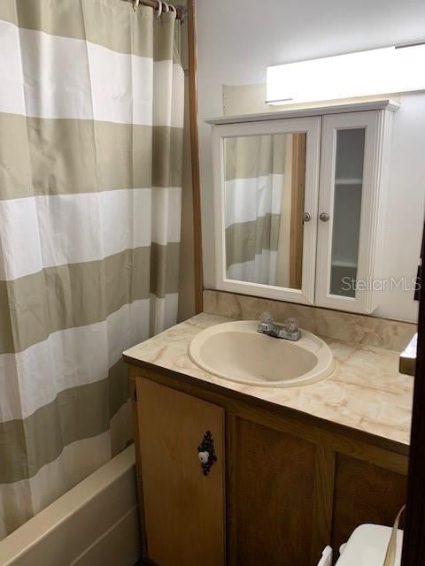 full bathroom with vanity, shower / bath combo, and toilet